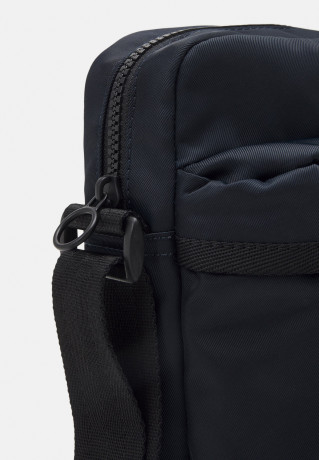 Tommy Hilfiger SKYLINE MINI REPORTER UNISEX Across body bag space blue SKYLINE MINI REPORTER UNISEX Сумка через плечо космический синий