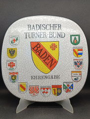 Тарелка декоративная винтажная Im Stil Karlsruhe Majolika &quot;Ассоцияция гимнатики Бадена&quot;, сувенирная, квадратной формы, с эффектом кракелюра, фарфор, 30.5 см, Германия, 1974 год.