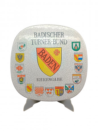 Тарелка декоративная винтажная Im Stil Karlsruhe Majolika "Ассоцияция гимнатики Бадена", сувенирная, квадратной формы, с эффектом кракелюра, фарфор, 30.5 см, Германия, 1974 год.