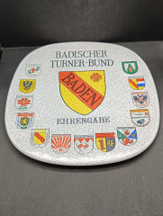 Тарелка декоративная винтажная Im Stil Karlsruhe Majolika &quot;Ассоцияция гимнатики Бадена&quot;, сувенирная, квадратной формы, с эффектом кракелюра, фарфор, 30.5 см, Германия, 1974 год.