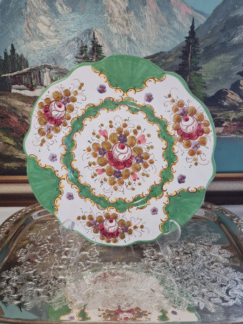 Тарелка винтажная декоративная Im Stil von Italy с округлым цветочным декором, в зеленовато-красных тонах, с фигурным краем, керамика, ручная роспись, 25.5 см, Италия, 1960-70гг.